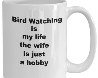 May include: White ceramic coffee mug with black text that reads "Bird Watching is my life the wife is just a hobby".