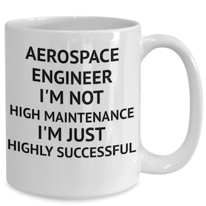 Op de afbeelding: Een witte keramische koffiemok met zwarte tekst die "Aerospace Engineer I'm not high maintenance I'm just highly successful" luidt