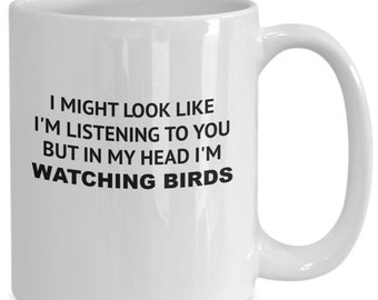 Puede incluir: Taza de café de cerámica blanca con texto negro que dice "Puedo parecer que te estoy escuchando, pero en mi cabeza estoy viendo pájaros."