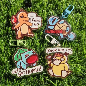 May include: Four acrylic keychains featuring cartoon characters. One orange character with text i... i frew up, one blue character with text wasted, one green character with text Let's get HUMID!, and one yellow character with text YOUR DID IT!.