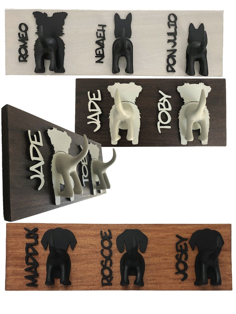 K&ouml;nnte beinhalten: Hakenleiste aus Holz mit drei schwarzen Haken in Form von Hundepopos und den Namen "Romeo", "Nevaeh" und "Don Julio", die vertikal auf der Leiste geschrieben sind.
