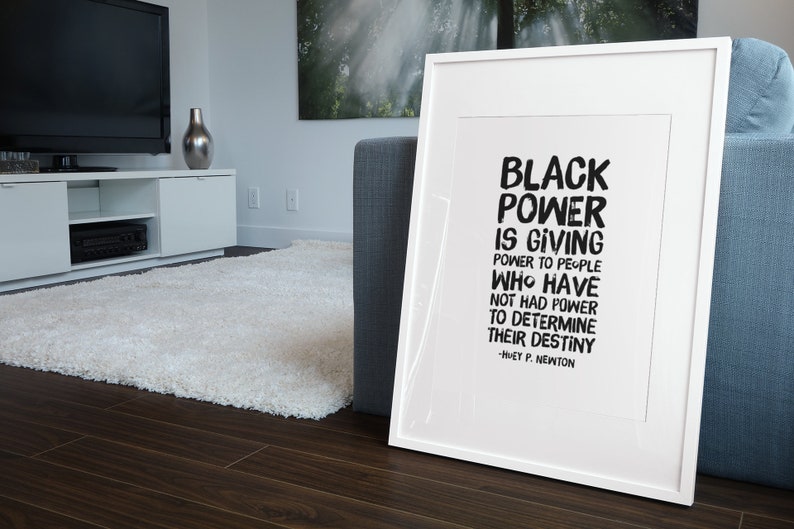May include: A framed black and white print with the quote "Black Power is giving power to people who have not had power to determine their destiny - Huey P. Newton".