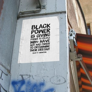 May include: A black and white poster with the text "Black Power is giving power to people who have not had power to determine their destiny - Huey P. Newton".