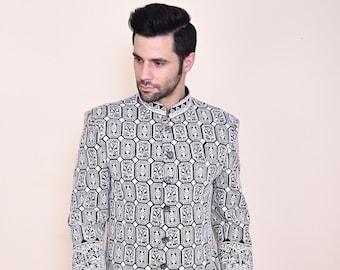 Könnte beinhalten: Eine langärmelige Jacke mit Mandarinkragen, die ein weiß-schwarzes geometrisches Muster aufweist. Die Jacke wird über einer schwarzen Hose getragen.