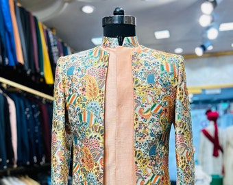 May include: A long, patterned jacket with a mandarin collar and a peach-colored inner lining. The jacket is made of a light-weight fabric and features a paisley print in shades of blue, green, yellow, and orange.