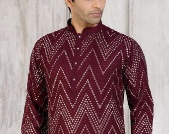 May include: A maroon long-sleeved kurta with a chevron pattern and white accents. The kurta has a button-up collar and is made of a lightweight fabric.