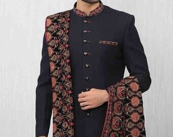 Könnte beinhalten: Eine marineblaue, langärmelige Kurta mit einem Mandarinkragen und Knopfleiste. Die Kurta wird mit einer weißen Hose und einem schwarzen und roten bestickten Schal getragen.