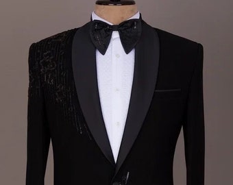 May include: A black tuxedo jacket with a satin lapel and a bow tie. The jacket has a unique design with black sequins on the front and sleeves.