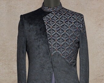 May include: A dark gray, long-sleeved jacket with a mandarin collar and an asymmetrical design. The jacket features intricate embroidered patterns in a diamond motif with red accents. The lower portion of the jacket is a solid, flowing fabric.