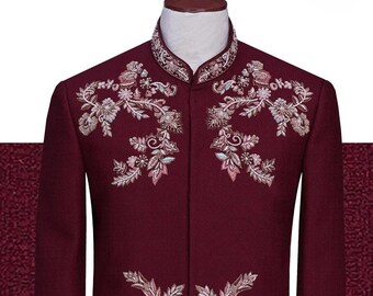 Puede incluir: Una chaqueta de hombre color granate con bordado floral intrincado en tonos de blanco, rosa y verde.