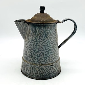 May include: Vintage enamelware coffee pot with a speckled gray and teal pattern. The pot has a spout, handle, and a lid with a black knob. The metal shows signs of age and wear, adding to its antique charm. A classic kitchenware item.