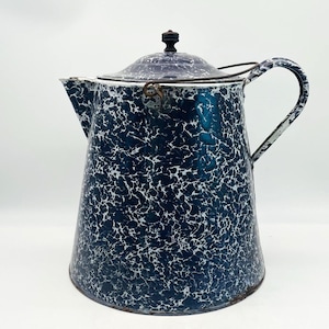 May include: A dark blue and white speckled enamel coffee pot with a tapered cylindrical body, a curved handle, a matching lid with a small dark knob, and a metal wire bail handle attached to the sides of the pot near the top rim.