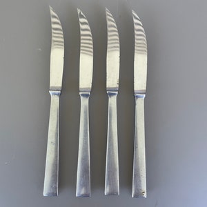 May include: Four silver steak knives with a brushed finish.