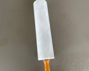 May include: A white marble rolling pin with wooden handles. The rolling pin is about 18 inches long.