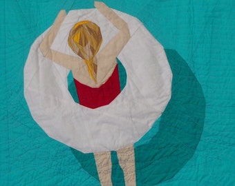 May include: A white inner tube with a person in a red swimsuit floating in a turquoise blue pool.
