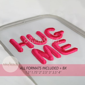 Op de afbeelding: Felroze borduurwerk op witte stof met de tekst "HUG ME". De afbeelding bevat ook de tekst "Aika Stitch" en "ALL FORMATS INCLUDED + BX" met maatopties van 1,5" tot 4".