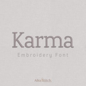 May include: A digital display of the word Karma in a serif embroidery font style, centered on a light gray textured background. Below the main text, the words Embroidery Font appear in a smaller sans-serif typeface, with Aika Stitch at the bottom.