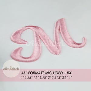 Op de afbeelding: Een roze geborduurde letter "M" in een cursief lettertype. De afbeelding bevat de tekst "Aika/Stitch" en "ALL FORMATS INCLUDED + BX" met maatopties van 2,5 cm tot 10 cm in een roze banner.