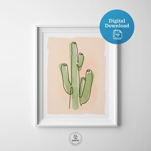 Printable wall art of green saguaro cactus on tan background. Shown in frame.