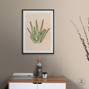 Printable wall art of green aloe plant on tan background. Shown in living room.