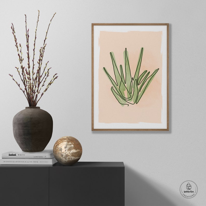 Printable wall art of green aloe plant on tan background. Shown in living room.