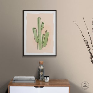 Printable wall art of green saguaro cactus on tan background. Shown in living room.