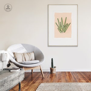 Printable wall art of green aloe plant on tan background. Shown in living room.