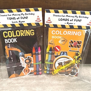 May include: Two clear plastic favor bags containing construction-themed coloring books and crayons. The bag toppers feature yellow and black caution stripes, traffic cones, and the text: Thanks For Making My Birthday TONS of FUN! Love, Ryan and LOADS of FUN! ~ Ryan ~.