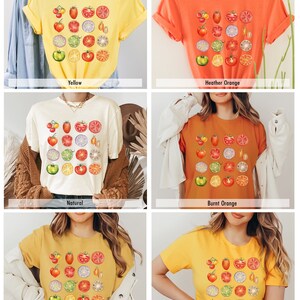 May include: Six different color t-shirts with a graphic print of sliced tomatoes, limes, and onions. The colors are yellow, heather orange, natural, burnt orange, heather mustard, and gold.
