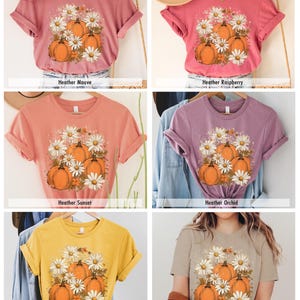May include: Six different colored t-shirts with a graphic print of pumpkins and daisies. The t-shirts are available in Heather Mauve, Heather Raspberry, Heather Sunset, Heather Orchid, Heather Yellow Gold, and Heather Tan.