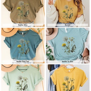 May include: Five different colored t-shirts with a vintage illustration of dandelions printed on the front. The colors are mustard yellow, heather olive, heather deep teal, heather ice blue, and heather prism dusty blue.