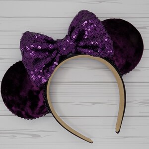 Peut inclure: Un serre-tête d'oreilles de souris en velours violet avec un nœud pailleté.