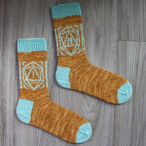 May include: A pair of brown and blue knitted socks with a dice pattern. The socks are made with a textured yarn and have a light blue cuff.