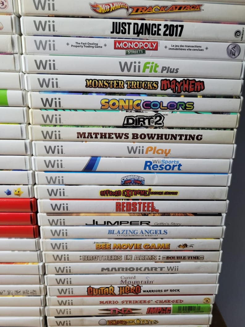 May include: A stack of 20 video game cases for the Nintendo Wii console. The games include titles like Just Dance 2017, Monster Trucks Mayhem, Sonic Colors, Dirt 2, and more.