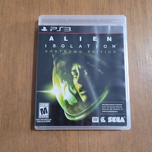 May include: A video game case for the PlayStation 3, featuring a green and black design with the title "Alien: Isolation - Nostromo Edition". The case includes a mature rating label and a Sega logo.