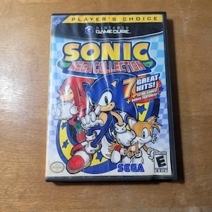 May include: A Nintendo GameCube video game case for Sonic Mega Collection. The cover features Sonic the Hedgehog, Knuckles, and Tails. The case has the "Player's Choice" label and the Sega logo.