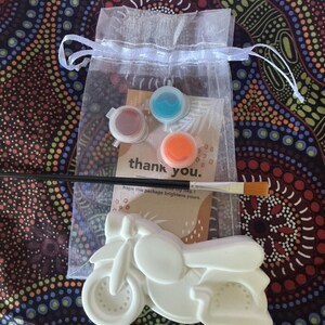 Peut inclure: Un kit de peinture de moto blanche. Le kit comprend trois petits pots de peinture rouge, bleu et orange, un pinceau et une carte avec l'inscription "thank you". Le kit est emballé dans un sac en organza blanc.