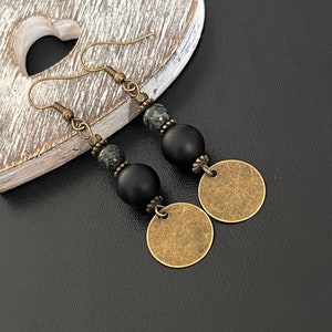 May include: A pair of dangle earrings with black and green beads and gold-toned circular charms.