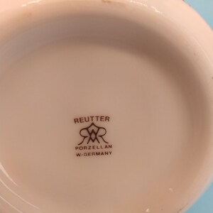 May include: Close-up of the bottom of a white porcelain dish with a brown logo that reads "Reutter Porzellan W-Germany".