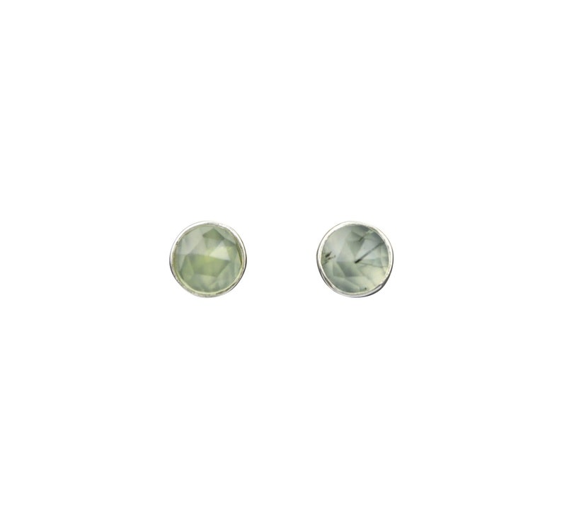 May include: A pair of silver stud earrings with light green faceted gemstones.