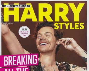 Op de afbeelding: Een tijdschriftcover met Harry Styles, zanger en acteur, met de titel "The Ultimate Guide to Harry Styles". De cover toont een close-up foto van Harry Styles die een paillettenvest draagt en lacht. De tekst "Breaking All The Rules!" staat in grote roze letters.