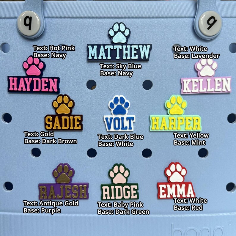 May include: A set of 10 colorful personalized name tags with paw prints. The tags are made of a soft, flexible material and are perfect for adding a personal touch to your belongings. The names on the tags are: Hayden, Matthew, Kellen, Sadie, Volt, Harper, Rajesh, Ridge, and Emma.