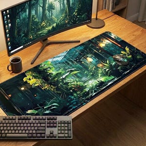 May include: A rectangular desk mat featuring a vibrant, detailed illustration of a lush indoor greenhouse filled with various green plants, ferns, and warm glowing lights, positioned on a wooden desk with a computer monitor and keyboard.