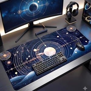 May include: A rectangular desk mat featuring a dark blue celestial design with white planetary orbits, stars, and a central moon. The mat is positioned on a desk surface beneath a black mechanical keyboard and a black computer mouse.