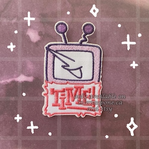 May include: An embroidered patch featuring a retro television set with two antennas and a lightning bolt graphic on the screen. Below the screen, the word TIME is stitched in red letters with an exclamation point, all on a white background.