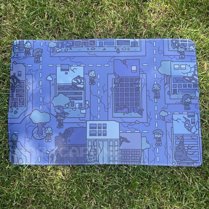 May include: A rectangular blue mouse mat with a detailed cartoon map of a town, featuring roads, buildings, and small figures. The design uses various shades of blue and white, creating a visually appealing and functional accessory.