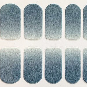 May include: A set of 10 nail wraps with a gradient design. The wraps are a light blue color at the top and fade to a white color at the bottom.