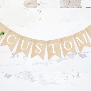 Puede incluir: Una pancarta de arpillera con la palabra "CUSTOM" en letras blancas. La pancarta está decorada con dos ilustraciones de tortugas verdes.