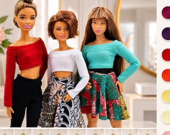 May include: Three dolls wearing long-sleeved off-the-shoulder crop tops in red, white, and turquoise. The first doll wears black pants, the second a patterned skirt, and the third a multi-colored skirt. A color palette of fabric swatches is shown.