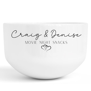May include: White ceramic bowl with the text "Craig & Denise Movie Night Snacks" and two intertwined hearts.